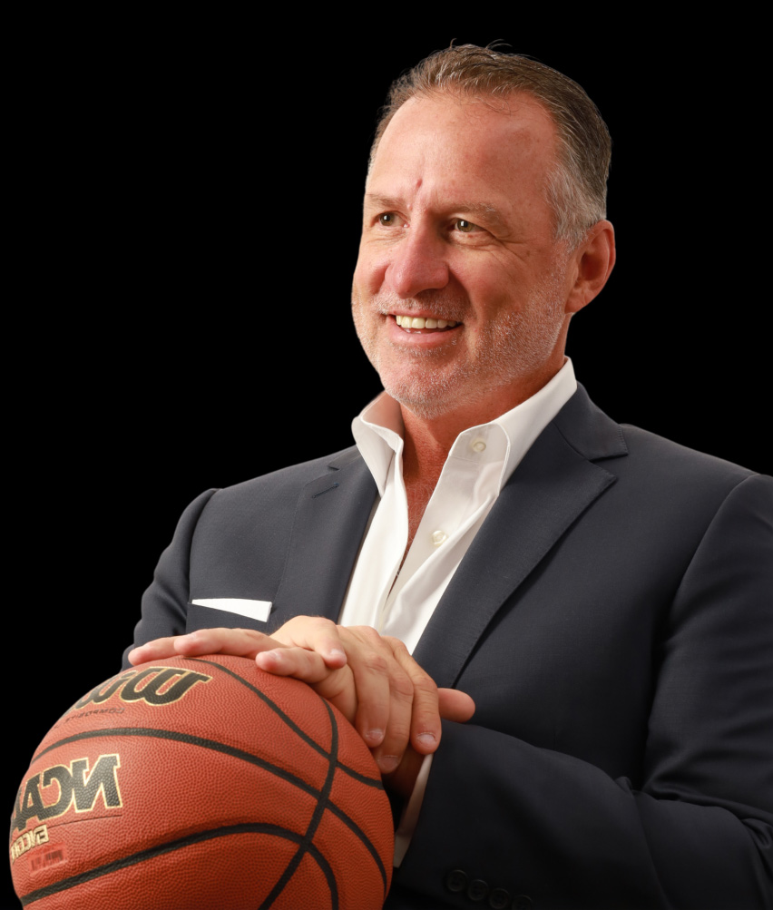 Mark Gottfried smiling while holding a basketball